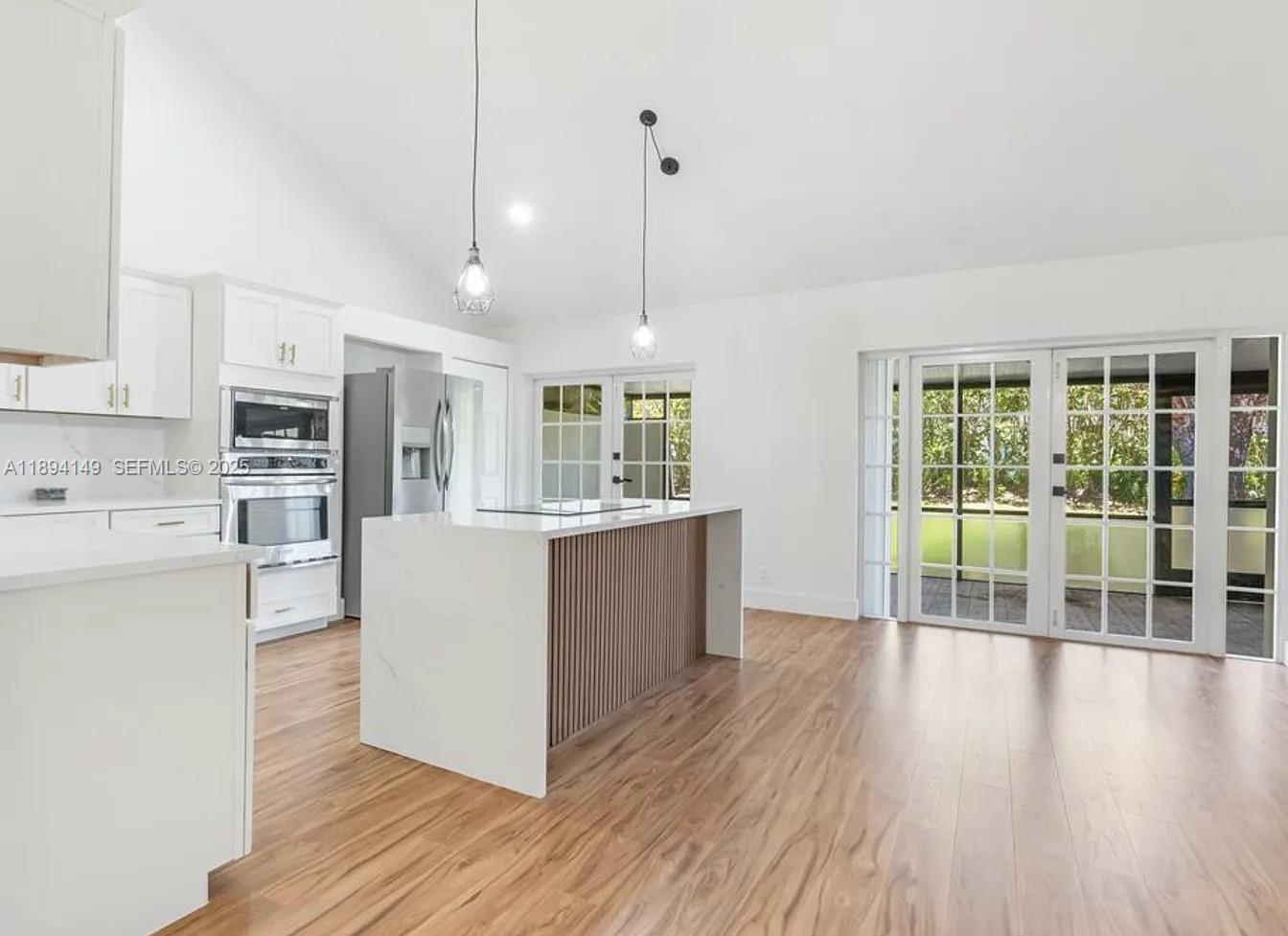 6850 Northwest 2nd Avenue, Unit 34 Boca Raton, FL 33487 - Photo 3 of 23 a kitchen with stainless steel appliances granite countertop a stove top oven a refrigerator a sink and dishwasher with wooden floor