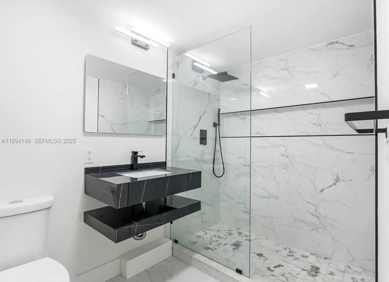 6850 Northwest 2nd Avenue, Unit 34 Boca Raton, FL 33487 - Photo 4 of 23 a bathroom with a sink a toilet and shower