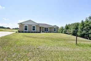 a view of a house with a yard and sitting area