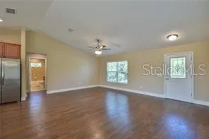 an empty room with wooden floor chandelier and glass door
