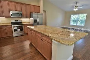 a kitchen with stainless steel appliances granite countertop a sink stove microwave and refrigerator