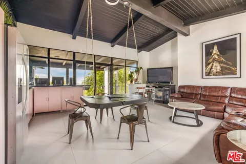 a living room with furniture a large window and a flat screen tv
