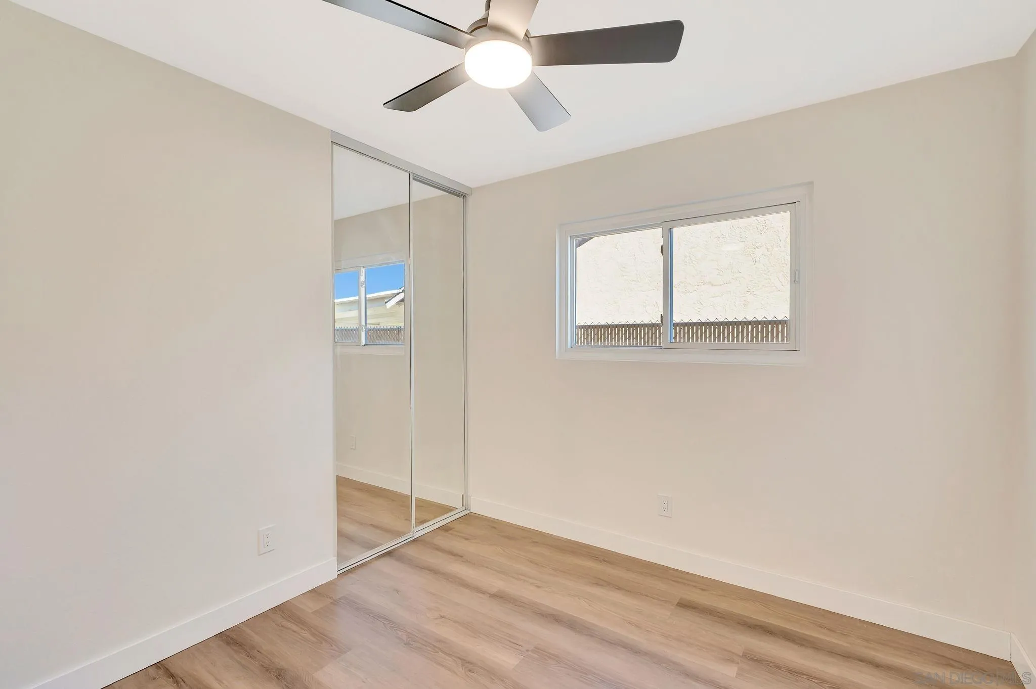 9421 Avenida Acero Spring Valley, CA 91977 - Photo 23 of 47 an empty room with wooden floor ceiling fan and windows