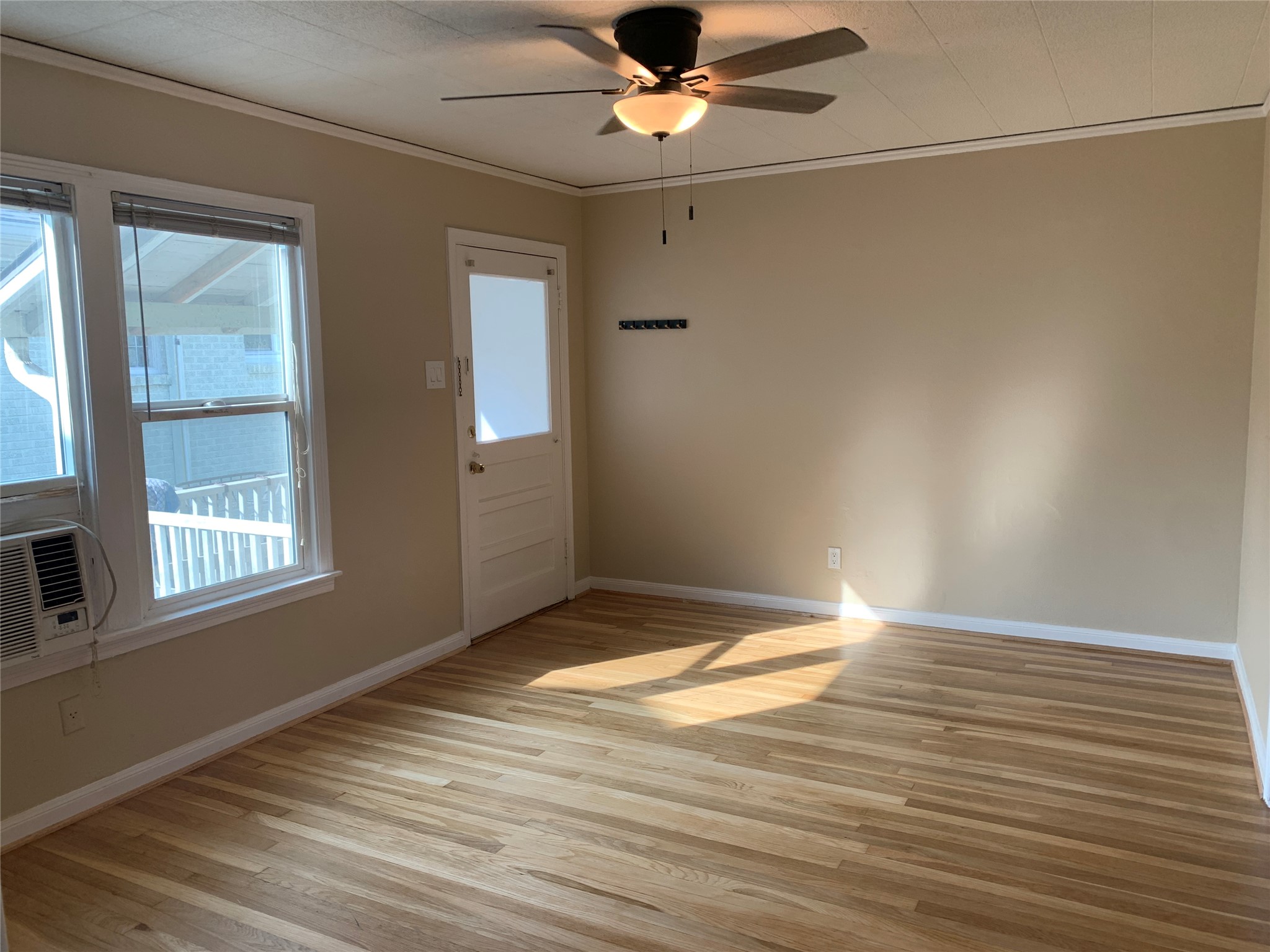 307 Avondale Street, Unit 1 5 Houston, TX 77006 - Photo 4 of 20 an empty room with wooden floor fan and windows
