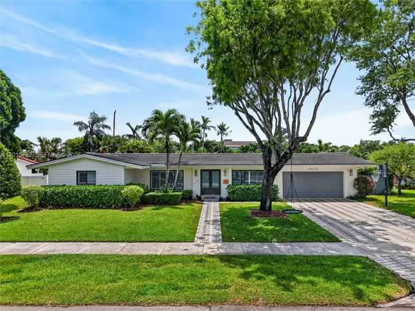 a front view of a house with a yard and trees