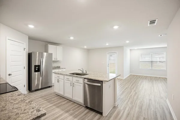 a kitchen with stainless steel appliances granite countertop a refrigerator and a stove top oven