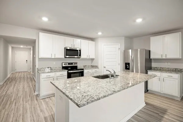 a kitchen with stainless steel appliances granite countertop a sink stove microwave and refrigerator