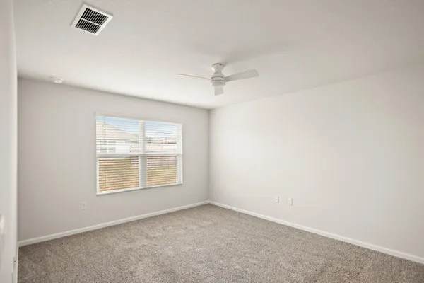 an empty room with a window and a ceiling fan
