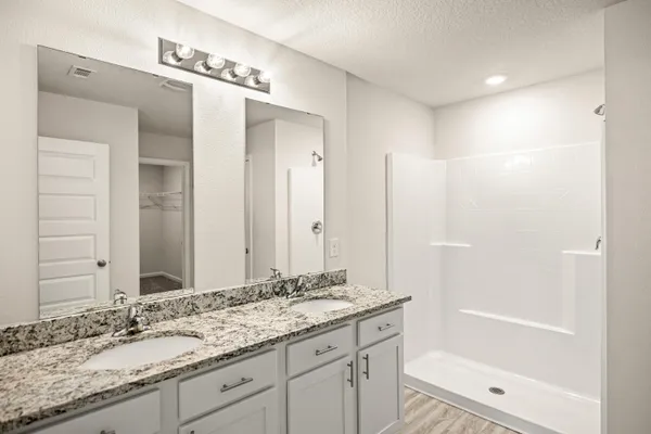 a bathroom with a granite countertop sink shower and a mirror