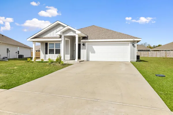 a front view of a house with a garden and yard