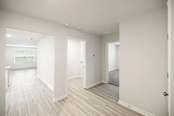 a view of a hallway with wooden floor and staircase