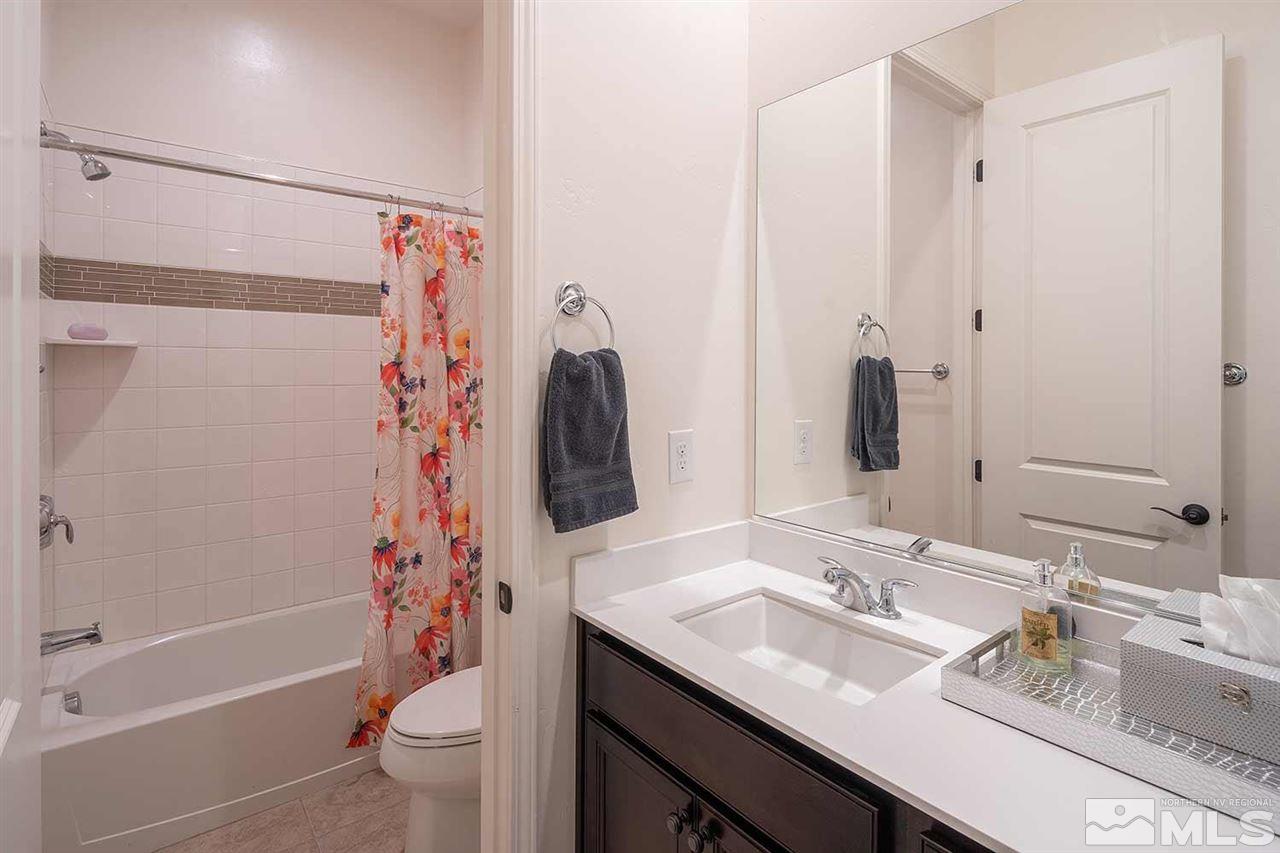 9404 Hawkshead Road Reno, NV 89521 - Photo 18 of 22 a bathroom with a granite countertop sink toilet and shower