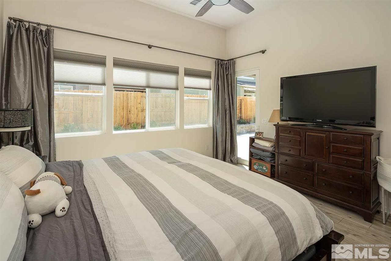 9404 Hawkshead Road Reno, NV 89521 - Photo 9 of 22 a bedroom with a bed and a flat tv screen on dresser