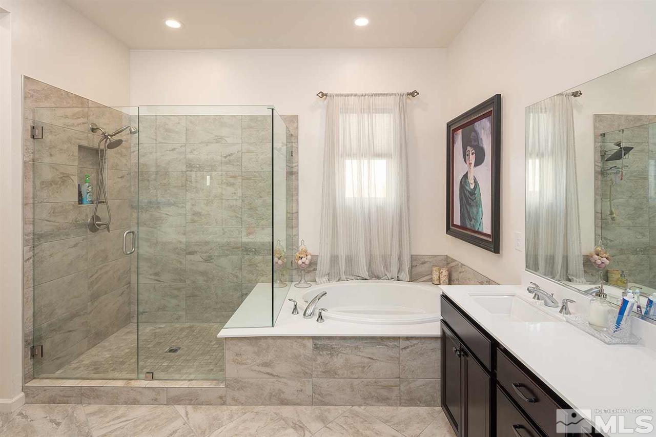 9404 Hawkshead Road Reno, NV 89521 - Photo 10 of 22 a bathroom with a tub shower sink and mirror