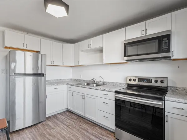 a kitchen with stainless steel appliances a stove microwave and refrigerator