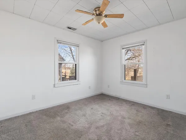 en empty room with windows and fan