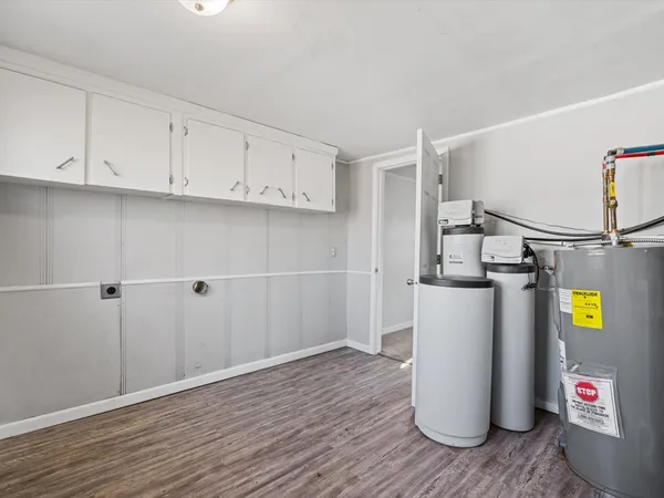 a view of storage and utility room with wooden floor and cabinet