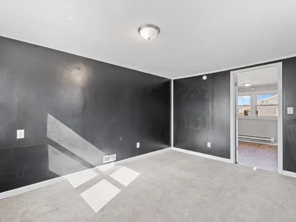 an empty room with closet and windows