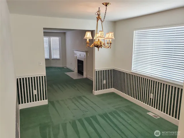a view of empty room with wooden floor and fireplace
