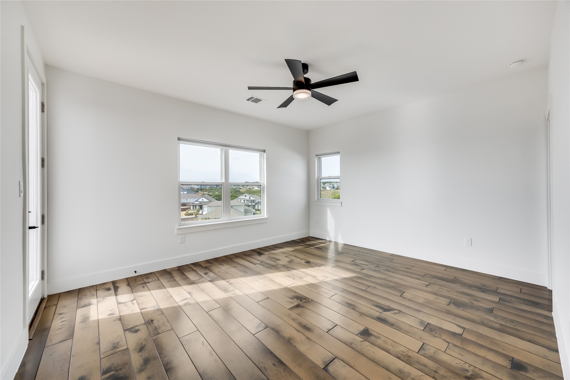 288 Smoke Tree Circle Dripping Springs, TX 78620 - Photo 31 of 40 an empty room with wooden floor and windows
