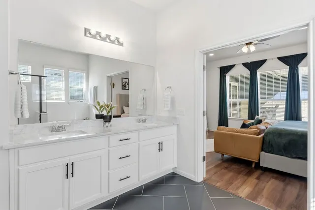 a spacious bathroom with a double vanity sink a mirror and a bathtub