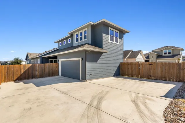 a view of a house with wooden fence