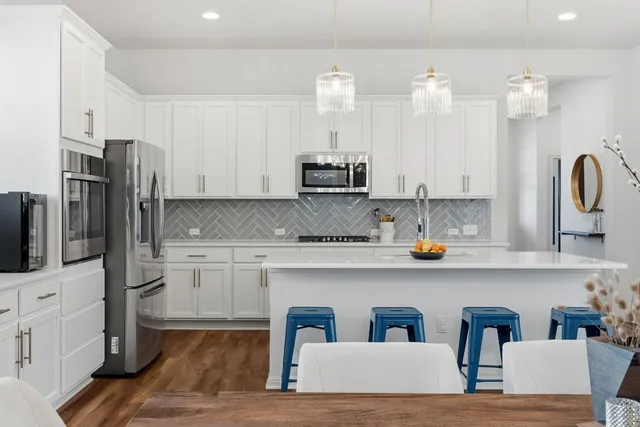 a kitchen with a stove a sink dishwasher a kitchen island with wooden cabinets and wooden floor