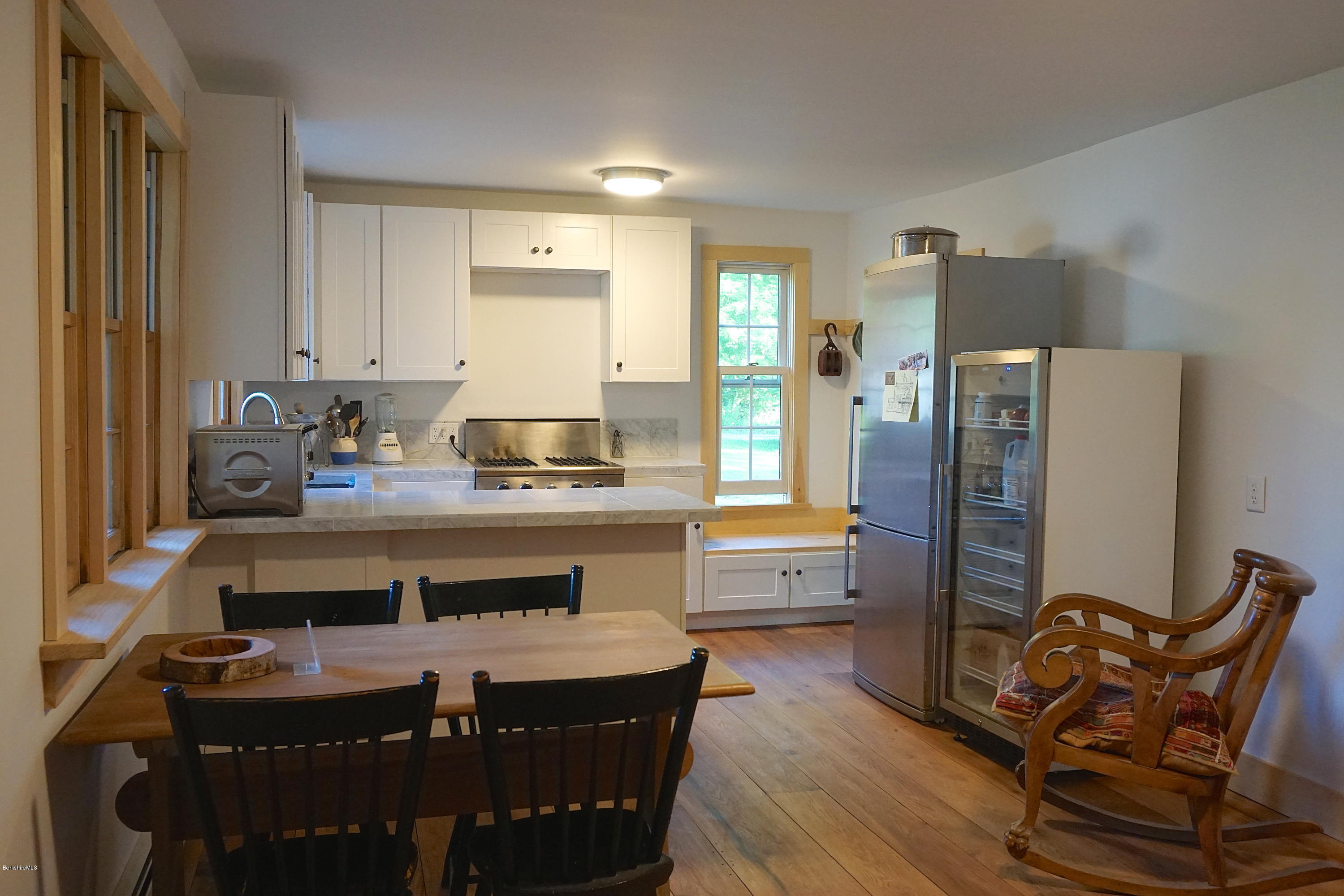519 Main Road Monterey, MA 01245 - Photo 8 of 28 a room with a table chairs and wooden floor