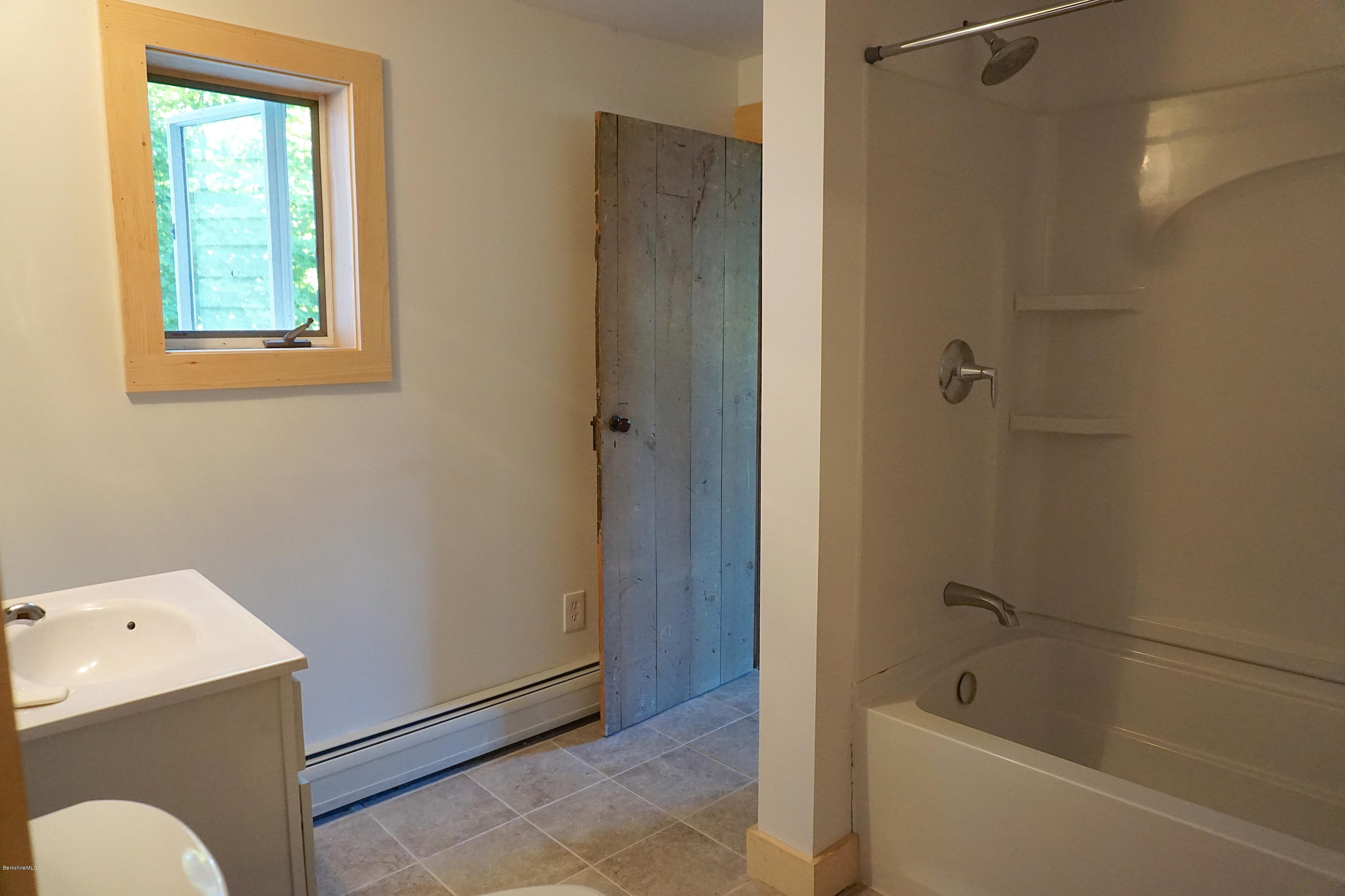 519 Main Road Monterey, MA 01245 - Photo 10 of 28 a bathroom with a tub a window and a shower