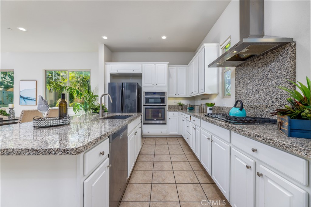 126 Interval Irvine, CA 92618 - Photo 11 of 47 a large kitchen with granite countertop a sink a counter top space appliances and cabinets