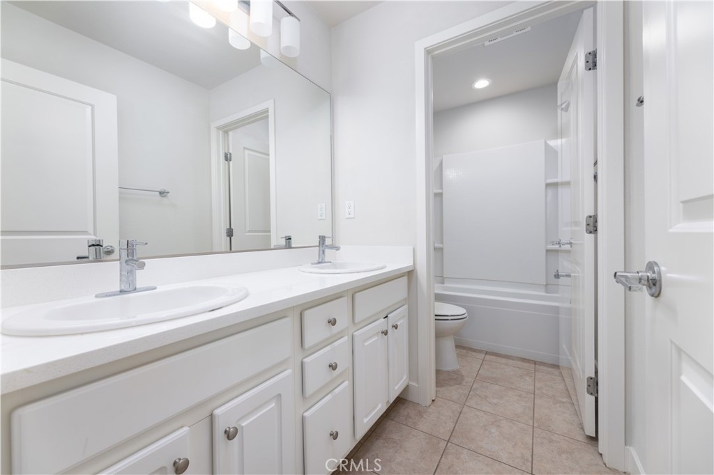 126 Interval Irvine, CA 92618 - Photo 24 of 47 a bathroom with a double vanity sink double mirror bathtub and next to a window