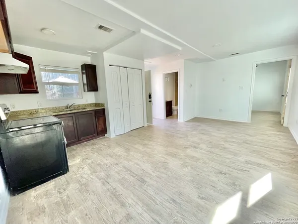 a view of a kitchen with stainless steel appliances wooden cabinets and a sink