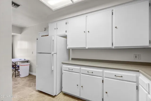 a kitchen with cabinets and a white refrigerator