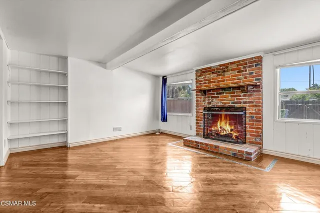 a view of an empty room with a fireplace and a window