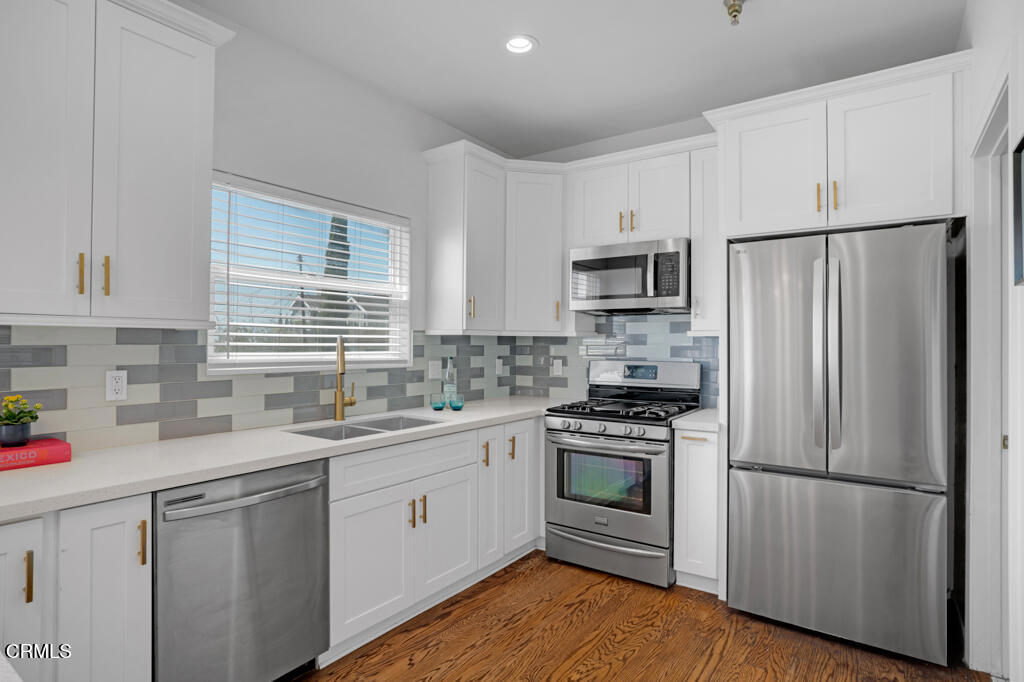 1300 Blue Hill Road Los Angeles, CA 90041 - Photo 19 of 54 a kitchen with white cabinets and stainless steel appliances