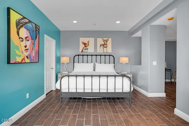 a bedroom with a bed and wooden floor