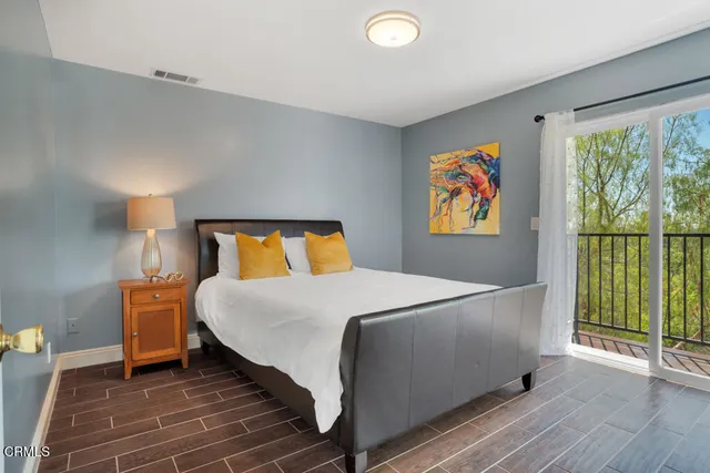 a bedroom with a bed and painting on the wall