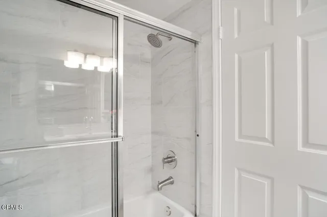 a view of a patio with couches and a fire pit and wooden fence
