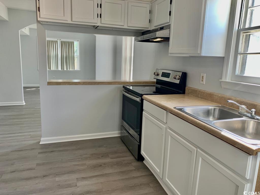 105 South Merriman Road, Unit 1 Georgetown, SC 29440 - Photo 13 of 22 Kitchen featuring electric stove, white cabinetry, light countertops, light wood-style flooring, and under cabinet range hood
