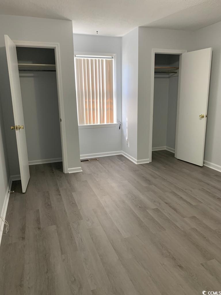 105 South Merriman Road, Unit 1 Georgetown, SC 29440 - Photo 21 of 22 Unfurnished bedroom featuring two closets and light wood-type flooring