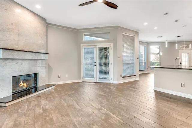 an empty room with wooden floor fireplace and windows
