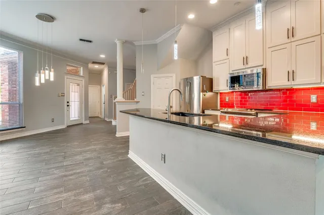 a kitchen with stainless steel appliances a sink and a refrigerator
