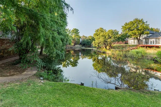 a backyard of a house with lots of green space and lake view