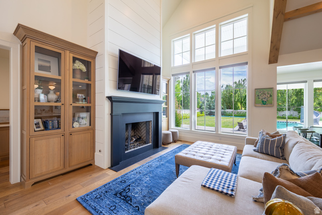630 East Center Street Alpine, UT 84004 - Photo 34 of 115 Vaulted living space featuring wood-finish flooring, a fireplace with a dark mantel, and expansive windows