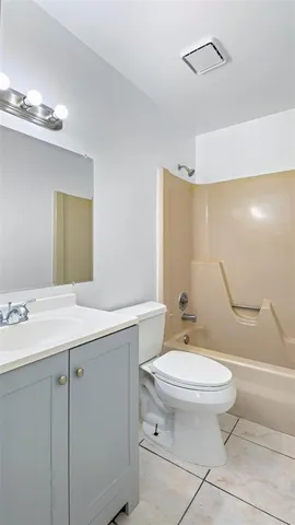 a bathroom with a granite countertop toilet sink and mirror