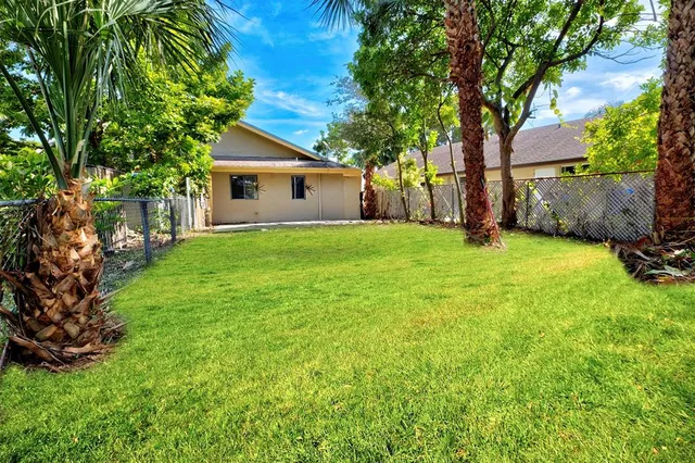 a backyard of a house with plants and large trees