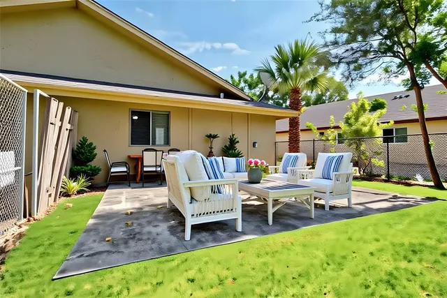 a view of a patio with table and chairs potted plants and a large tree
