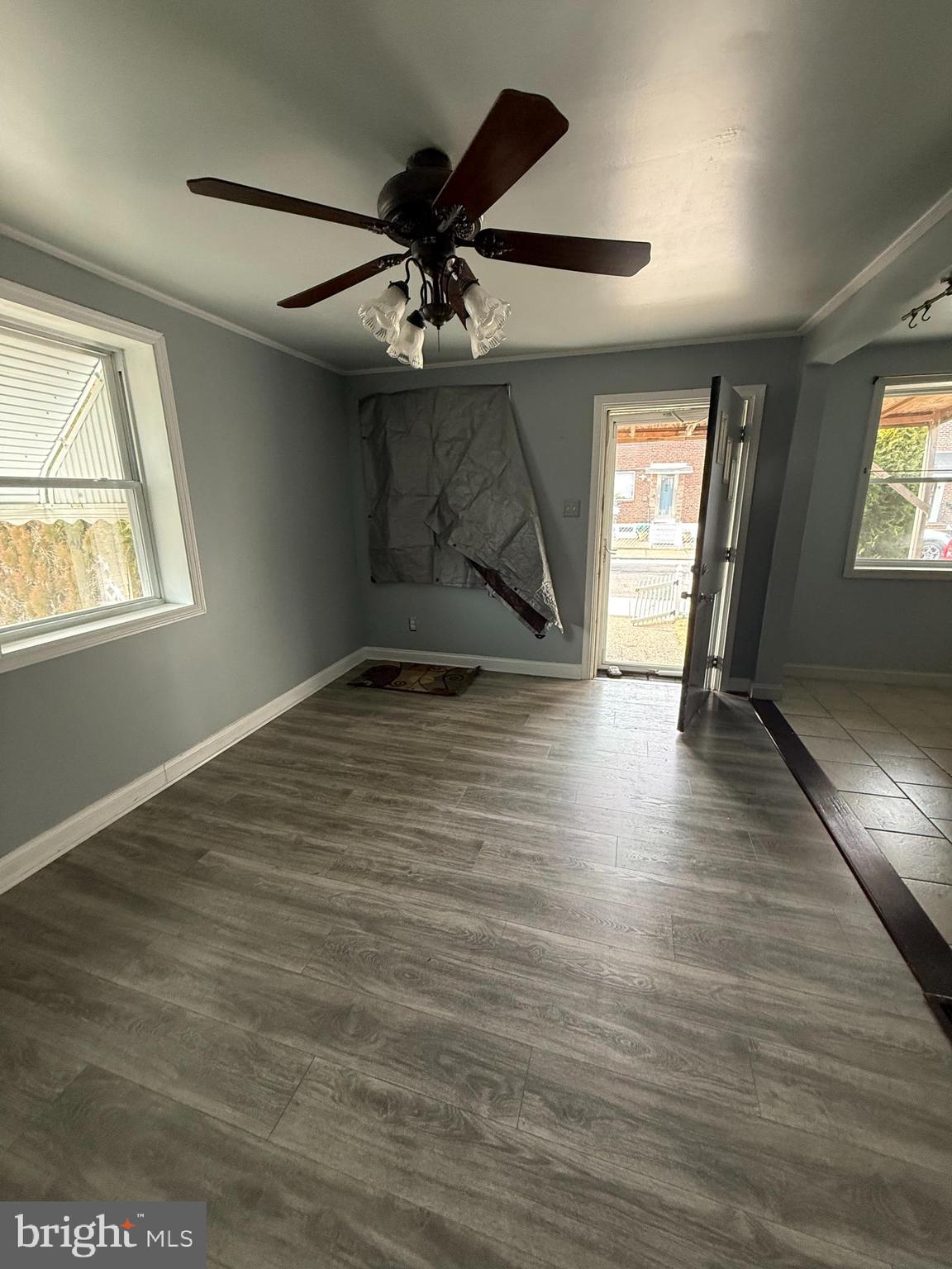 1841 South 28th Street Philadelphia, PA 19145 - Photo 7 of 9 an empty room with wooden floor chandelier fan and windows