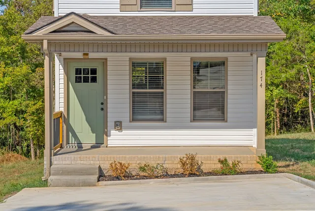 a front view of a house with a garden and plants