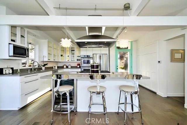 a kitchen with stainless steel appliances kitchen island granite countertop a table and chairs in it